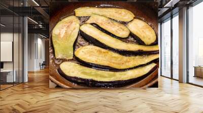 Eggplants are fried in oil in a pan Wall mural