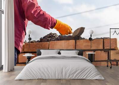 Worker builds a brick wall in the house Wall mural