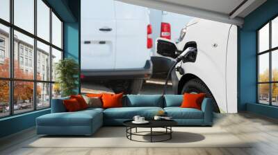 electric delivery van with connected charging cable. Wall mural