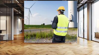 Engineer with digital tablet works on a field of wind turbines Wall mural