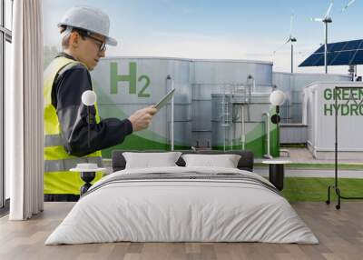 Engineer with tablet computer on a background of green Hydrogen factory	 Wall mural