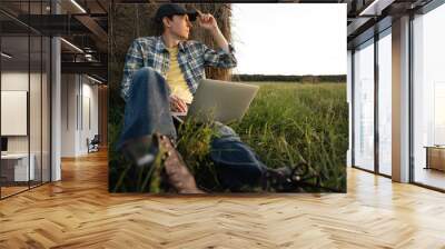 Farmer with laptop on the field. Smart farming and agriculture digitalization Wall mural