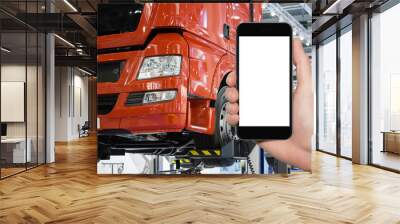 Hand with phone on a background of truck on a lift in a car service Wall mural