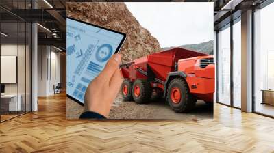 Man controls autonomous mining truck using digital tablet Wall mural