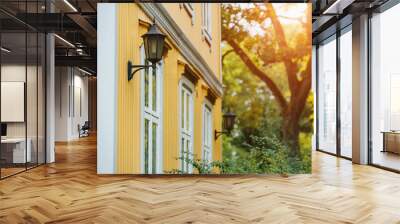 Wall of a yellow wooden house with a lantern Wall mural