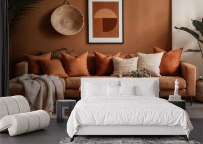 A modern living room featuring an earthy brown couch with cushions, art on the walls, and indoor plants creating a cozy and inviting atmosphere.

 Wall mural