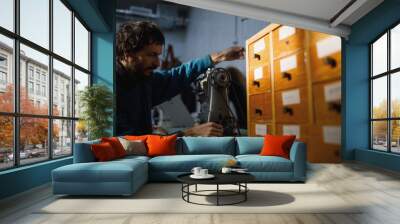 A leather craftsman works in a workshop.  Wall mural