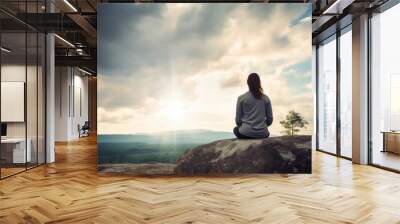 Woman meditating on a mountain top Wall mural