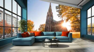 Beautiful Gothic Revival style cathedral at sunset, with golden warm light illuminating the fall foliage around the structure.  Wall mural