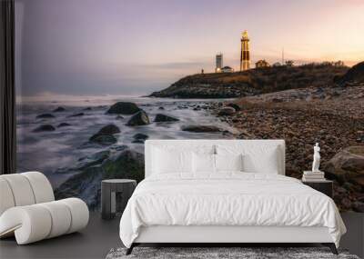 Lighthouse lit up with Christmas lights in a winter seascape along a rocky coast. Montauk State Park, New York.   Wall mural