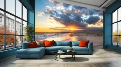 Sun burst breaking through soft colorful clouds as the sun sets over an empty open beach. Long Island New York Wall mural