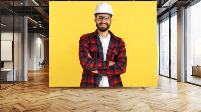 Attractive bearded engineer or constructor man in plai shirt standing over yellow background. Looking in camera. Wall mural