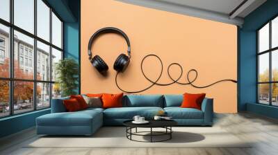 Photo of stylish modern black headphones over beige background. Wall mural