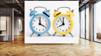 Two round alarm clocks yellow and blue on the white background. Wall mural