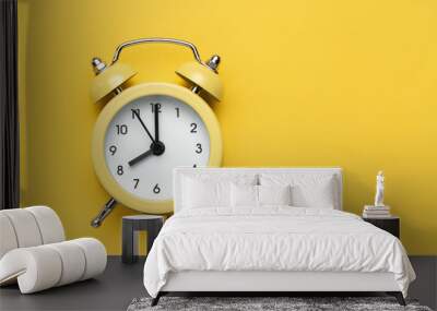 Yellow round alarm clock on the yellow background. Wall mural