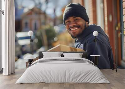 Smiling delivery person holds a package. Wall mural