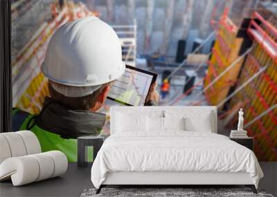 civil engineer or architect on construction site checking schedule with tablet computer Wall mural