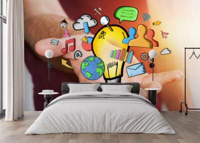 businessman holding hand drawn lightbulb and multimedia icons Wall mural