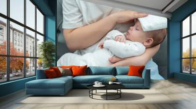 Wet towel comforts a feverish infant, Concept of mother's instinctive care response Wall mural