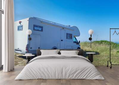 caravan car and dog parked on the grass by the sea in greece Wall mural