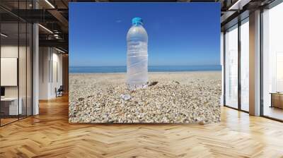 water bottle frozen cold on the sand of the beach in a hot summer day Wall mural