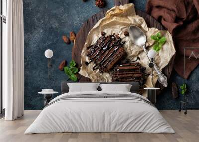 chocolate brownie cake, dessert with nuts on dark background, directly above, flat lay Wall mural