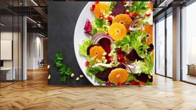 Christmas salad with boiled beet, red onion, tangerines, pomegranate, parsley, pine nuts and lettuce leaves Wall mural