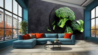 Fresh broccoli florets on black background, top view Wall mural