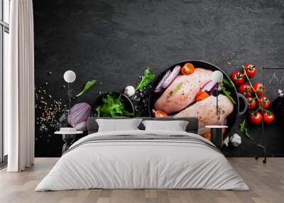 Fresh raw chicken meat, fillet marinated with spices, onion and tomatoes on black background. Top view Wall mural