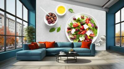 Greek salad with greens, olives and feta chesse on a white plate, top view Wall mural