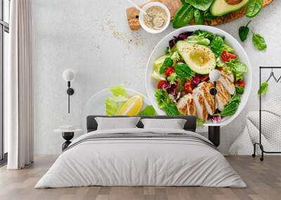 Grilled chicken meat and fresh vegetable salad of tomato, avocado, lettuce and spinach. Healthy and detox food concept. Ketogenic diet. Buddha bowl dish on white background, top view Wall mural