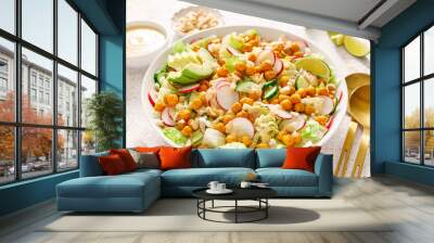 Healthy spring vegan Caesar salad with chickpea, fresh cucumber, radish, avocado and crispy croutons, dressed with garlic sauce. Wall mural