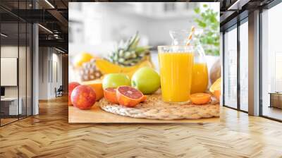 Multifruit juice and fresh fruit on table on kitchen background closeup Wall mural