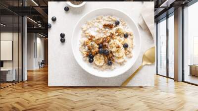 Oatmeal bowl. Oat porridge with banana, blueberry, walnut, chia seeds and almond milk for healthy breakfast or lunch. Healthy food, diet. Top view. Wall mural