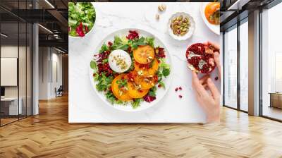 Salad with persimmon, burrata, pomegranate and pistachio, healthy food, top view Wall mural