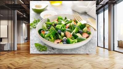 Salmon fish and avocado salad with fresh spinach leaves, broccoli, blueberry dressed with olive oil Wall mural