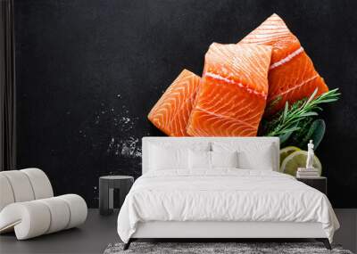 Salmon. Fresh raw salmon fish fillet with cooking ingredients, herbs and lemon on black background, top view Wall mural