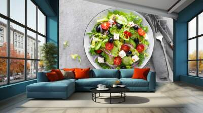 Vegetable salad with fresh cucumber, tomato, olive, onion, lettuce and feta cheese. Healthy food. Top view Wall mural