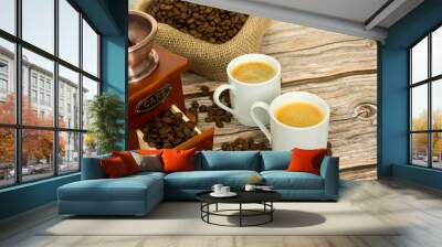 Composition with coffee. Wooden coffee grinder, beans in a bag and two cups of freshly brewed coffee. Image with selective focus Wall mural