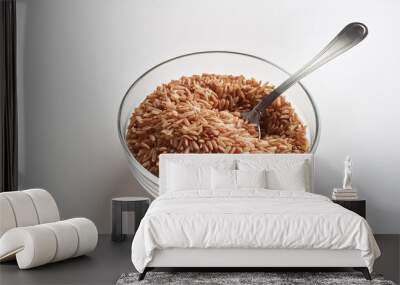 a glass plate contains brown rice with a spoon on a white background close up with space for the inscription Wall mural