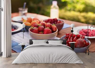 a lunch table outside with bowls of fruit strawberries raspberries pomegranate Wall mural