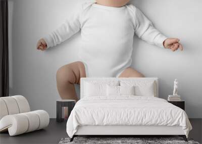 Baby lying on back wearing white onesie mockup Wall mural