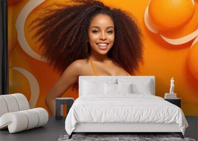 A young, beautiful Brazilian woman with an afro hairstyle wearing an orange bikini top, standing in front of an orange background. She has a confident and elegant pose and a very nice body. Wall mural