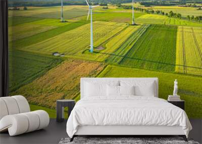 Aerial drone view of wind power turbines, part of a wind farm. Wind turbines on green field in countryside. Wind power plant. Wall mural