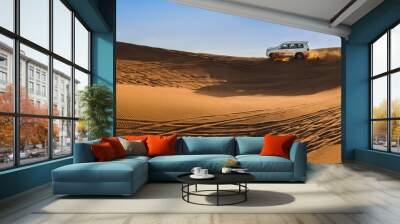 white jeep driving through the desert sand dunes on the background of the sky Wall mural