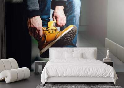 Putting shoes in the hall, preparing for the exit. The man puts on a foot a brown shoe. The concept of leaving home, leaving the premises. Wall mural