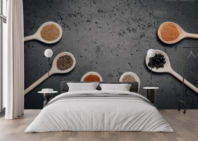 Top view on a set of spices on a stone table. The concept of using seasonings for dishes, various spices on wooden spoons. Wall mural