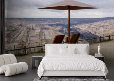 two empty deck chairs with an umbrella made of metal in front of open pit mining of hambach terra nova in germany Wall mural