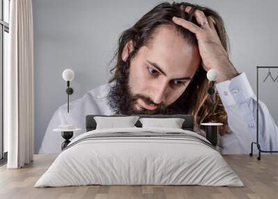 portrait of a young middle eastern businessman with beard and long hair adjusting his hair Wall mural