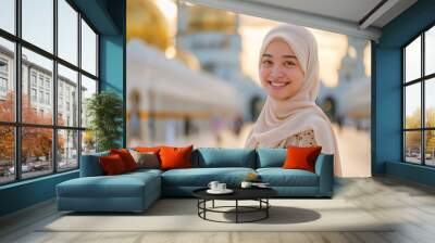 a happy young lady wearing stylish hijab with a mosque background Wall mural